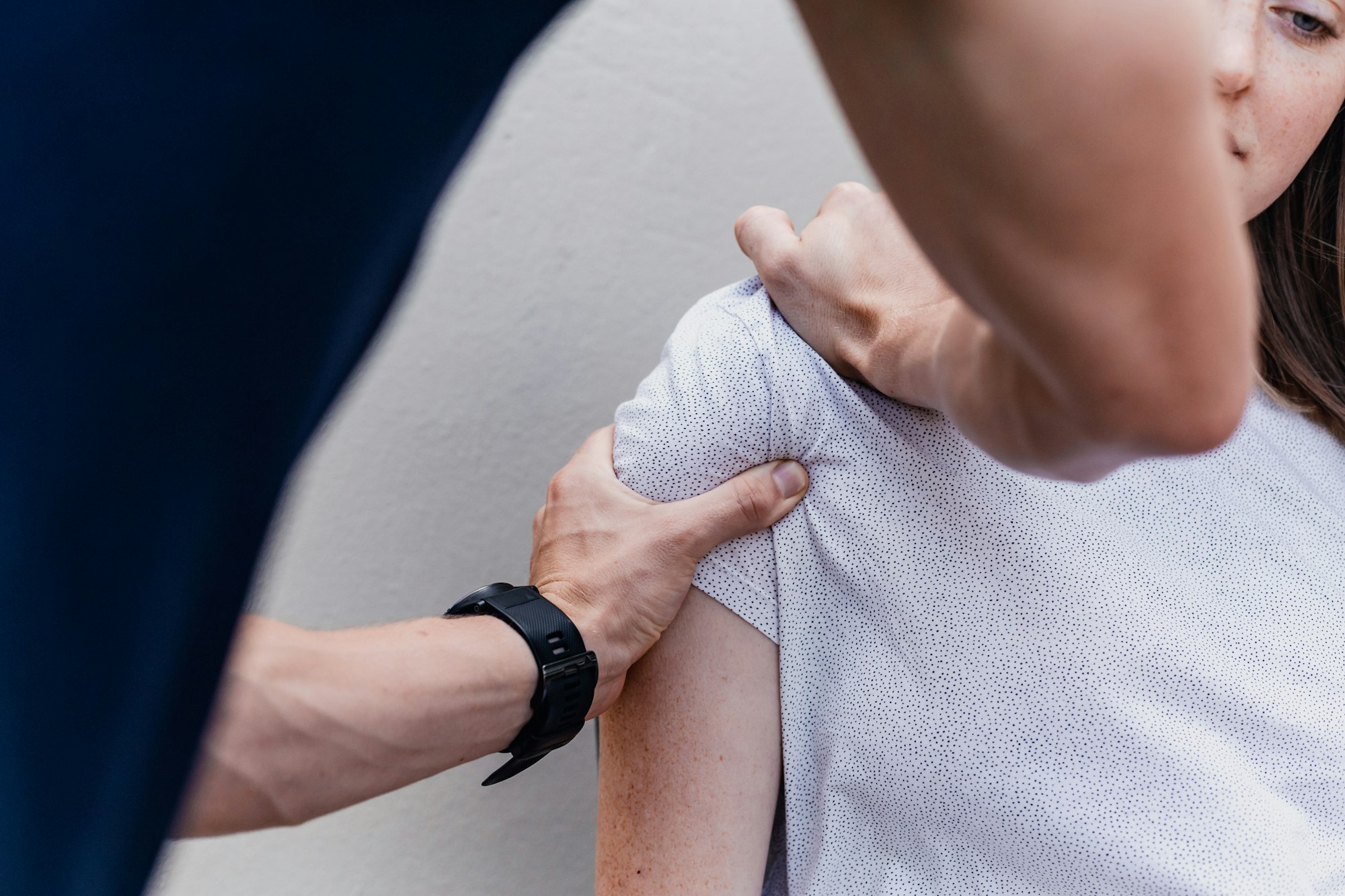 A physiotherapist assessing a client's shoulder
